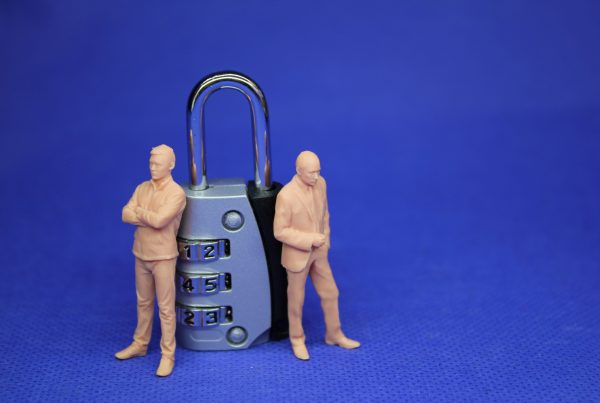 figurines of people stood next to a metal padlock